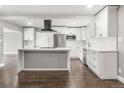 Newly renovated kitchen boasts white cabinetry, stainless steel appliances, and a central island cooktop at 748 W 100Th Ave, Northglenn, CO 80260