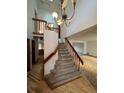 Bright and spacious foyer featuring a staircase with wooden banister and chandelier, leading to the upper level at 5151 S Laredo Ct, Centennial, CO 80015