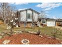 Landscaped front yard with decorative rock garden, mulched beds, and artistic metal flower sculptures at 9605 W David Ave, Littleton, CO 80128