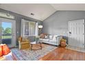 Comfortable living room featuring a vaulted ceiling, hardwood floors, and ample natural light at 8481 W Union Ave # 13203, Denver, CO 80123