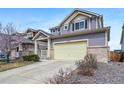 Charming two-story home featuring a two-car garage, well-maintained lawn, and inviting covered front porch at 18039 E 108Th Pl, Commerce City, CO 80022
