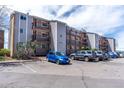 Multi-story condo building featuring private balconies and ample parking with a mountain view in the background at 8666 Decatur St # 254, Westminster, CO 80031