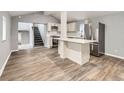 Open kitchen and living area featuring new floors, grey paint, and modern appliances at 825 S Quitman St, Denver, CO 80219