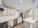 Bright kitchen with white cabinets, quartz countertops, and stainless steel appliances at 825 S Quitman St, Denver, CO 80219
