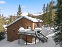 Charming wood cabin with a deck covered in fresh snow nestled in a picturesque mountain setting at 493 Cr 672, Breckenridge, CO 80424