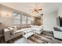 Bright living room featuring a large sectional sofa, ceiling fan, and wood-look floors at 23882 E Alabama Dr, Aurora, CO 80018