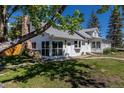 Exterior view of a charming home featuring stone chimney and mature trees on a sunny day at 5195 Allison St, Arvada, CO 80002