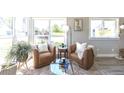 Bright living room with hardwood floors, two leather chairs, accent rug, natural light, and modern decor create a cozy atmosphere at 5195 Allison St, Arvada, CO 80002