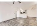 Open-concept living room with hardwood floors, white walls, and a view of the kitchen at 18657 Stroh Rd # 4103, Parker, CO 80134