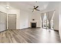 Bright living room featuring a fireplace, ceiling fan, and large window with gray curtains at 18657 Stroh Rd # 4103, Parker, CO 80134