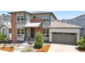 Charming two-story home with modern gray and brick exterior, complemented by a lush, landscaped front yard at 9340 Mount Jackson St, Littleton, CO 80125