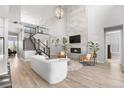 Spacious living area with a fireplace and staircase, complemented by hardwood floors and natural light at 9340 Mount Jackson St, Littleton, CO 80125