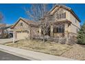 Inviting two-story home featuring stone accents, a well-maintained front lawn, and attached garage at 13987 Lexington Dr, Parker, CO 80134