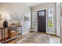 Bright foyer featuring wood floors, stylish console table and neutral decor, perfect for a warm welcome at 8890 S Quatar Ct, Aurora, CO 80016