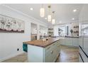 Modern kitchen with light green cabinets, butcher block island, and stainless steel appliances at 190 W 1St Ave, Broomfield, CO 80020