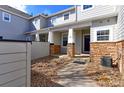 Exterior view of a townhome with gray siding and red brick accents at 2550 Winding River Dr # F2, Broomfield, CO 80023