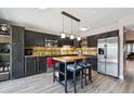 Kitchen with butcher block island, stainless steel appliances, and dark cabinetry, with eat-in breakfast bar at 6495 E Happy Canyon Rd # 163, Denver, CO 80237