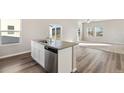 Modern kitchen island with stainless steel dishwasher and sink, connecting to the living room at 2958 Oxley St, Strasburg, CO 80136