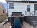 Charming exterior with a blue door leading to a finished basement and gray stair access at 2626 S Pennsylvania St, Denver, CO 80210
