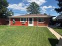 View of the cozy backyard with vibrant green lawn and access to the home's rear entrance at 25 S Winona Ct, Denver, CO 80219