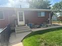 Exterior showcasing a charming brick home with green lawn and patio furniture at 25 S Winona Ct, Denver, CO 80219