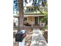 Traditional home exterior featuring a covered porch and landscaped front yard at 2156 Federal Blvd, Denver, CO 80211