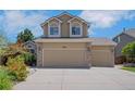 Front exterior showcasing a 3-car garage and well-maintained driveway in a cozy home at 8884 Miners St, Highlands Ranch, CO 80126