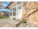Front exterior showcasing a brick facade, large windows, manicured shrubs, and decorative stone landscaping at 5373 S Prescott St, Littleton, CO 80120