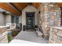 Inviting front entrance featuring a stone facade, a modern door, and a cozy seating area at 15116 Lyons Ridge Dr, Morrison, CO 80465