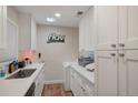 Clean kitchenette features sleek white cabinets, modern appliances, and a minimalist design at 3298 S Eudora St, Denver, CO 80222