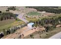 Aerial shot of the property, showcasing mature trees, the athletic fields, and proximity to local roads at 10550 Highway 73, Conifer, CO 80433