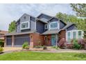 Charming two-story home featuring a brick facade, blue siding, and a well-kept lawn at 7831 W 109Th Ave, Westminster, CO 80021