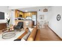 Open floor plan with kitchen, dining area, and cozy living room showcasing light wood floors at 3663 S Sheridan Blvd # H15, Denver, CO 80235