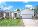 Classic home with a two-car garage, tidy landscaping and sidewalk-lined street at 7410 Winter Berry Ln, Castle Pines, CO 80108