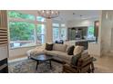 Bright open-concept living room with large windows, modern furnishings, and elegant decor at 7410 Winter Berry Ln, Castle Pines, CO 80108