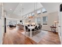 Open-concept dining room with vaulted ceilings, modern lighting, and seamless flow to kitchen at 1721 S Jackson St, Denver, CO 80210