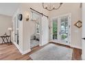 Bright foyer featuring wood floors, stylish lighting, and a sliding barn door to office space at 1721 S Jackson St, Denver, CO 80210