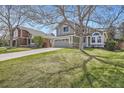 Beautifully landscaped front yard with mature trees, complementing the home's curb appeal at 746 Poppywood Dr, Highlands Ranch, CO 80126