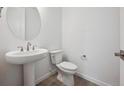 Stylish half bathroom with a pedestal sink and modern fixtures at 6986 E 126Th Pl, Thornton, CO 80602