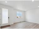 Bright, airy room with wood floors, a window, and a glass door at 6986 E 126Th Pl, Thornton, CO 80602