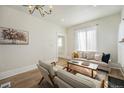 Inviting living room with modern decor, including a comfortable sofa, chairs, and a beautiful painting at 719 W 7Th Ave, Denver, CO 80204