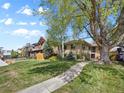 Beautiful home with a spacious front yard, mature trees, and a walkway to the entrance at 746 Birch St, Denver, CO 80220