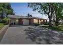 A well-maintained home featuring a carport and large concrete driveway at 2902 S Meade St, Denver, CO 80236