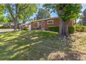 Charming brick home with a well-manicured lawn and mature trees in a serene setting at 2902 S Meade St, Denver, CO 80236