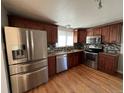 Spacious kitchen featuring stainless steel appliances, wood cabinets, and granite countertops at 1245 Yates St, Denver, CO 80204
