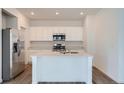 Modern kitchen with stainless steel appliances, quartz countertops, and a spacious island at 15242 Detroit St, Thornton, CO 80602
