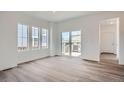 Open living space with hardwood floors, natural light, and sliding glass door at 15242 Detroit St, Thornton, CO 80602