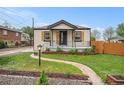 Inviting home featuring a lovely front porch and well-kept lawn with landscape features at 5491 Lowell Blvd, Denver, CO 80221