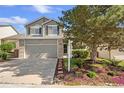 Beautiful two-story home with a well-kept lawn and mature landscaping, with tan siding and brick accents at 4857 Tarcoola Ln, Highlands Ranch, CO 80130