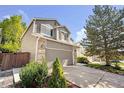This two-story home has a two-car garage, brick accents, and mature trees at 4857 Tarcoola Ln, Highlands Ranch, CO 80130